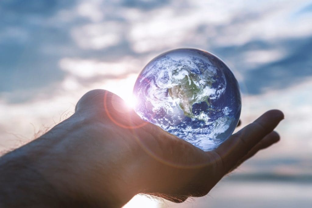 Person holding a glass globe of the world