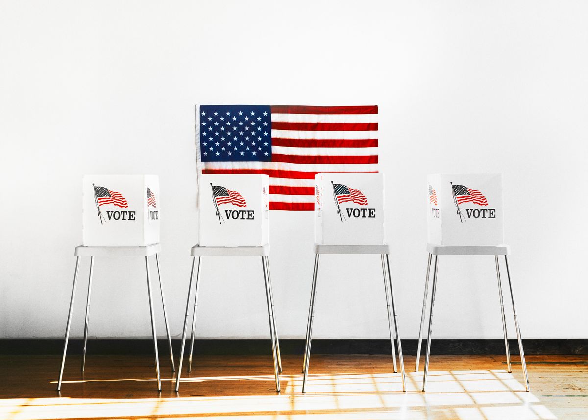 American flag on a wall with four signs in front saying Vote