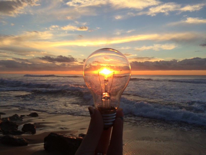 a lightbulb symbolizing ideas in front of a sunset