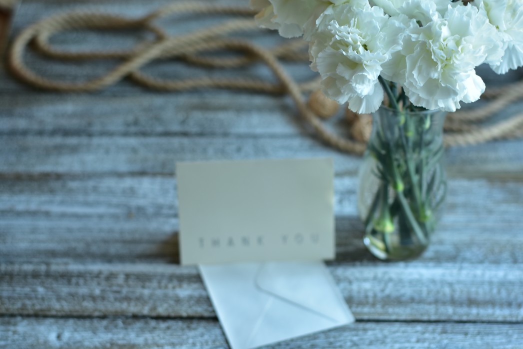 a thank you note with a small bouquet of white flowers