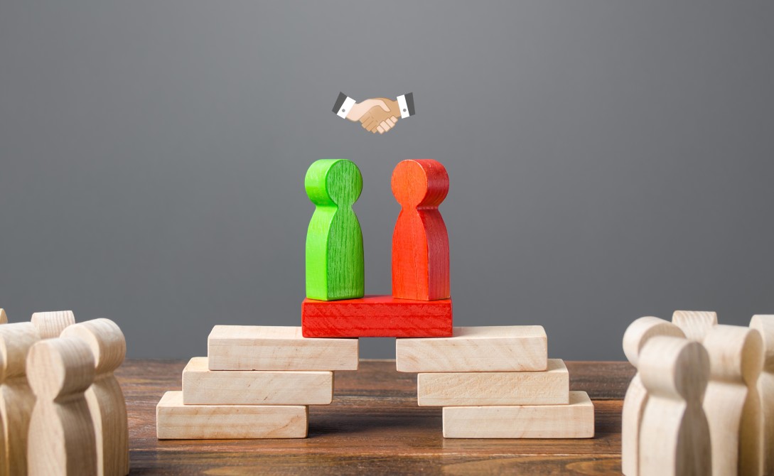 two wooden figures shaking hands to show agreement