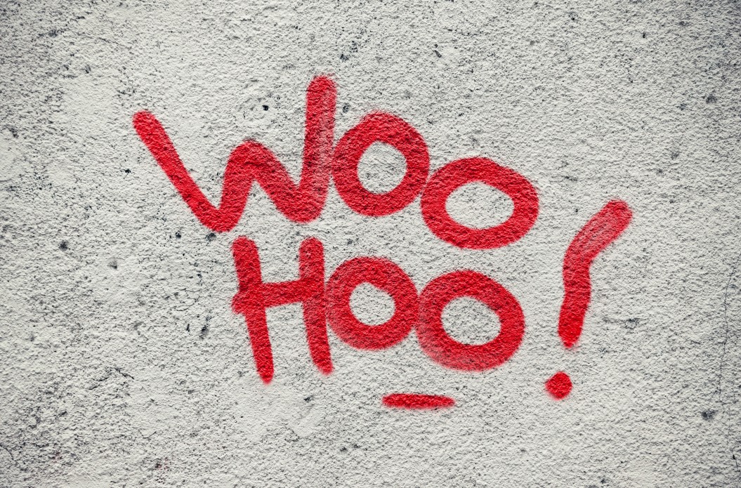 Wall Joy that says Woo Hoo! on concrete background
