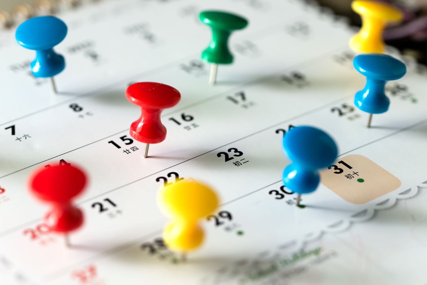 Thumb tack pins on a calendar as a reminder