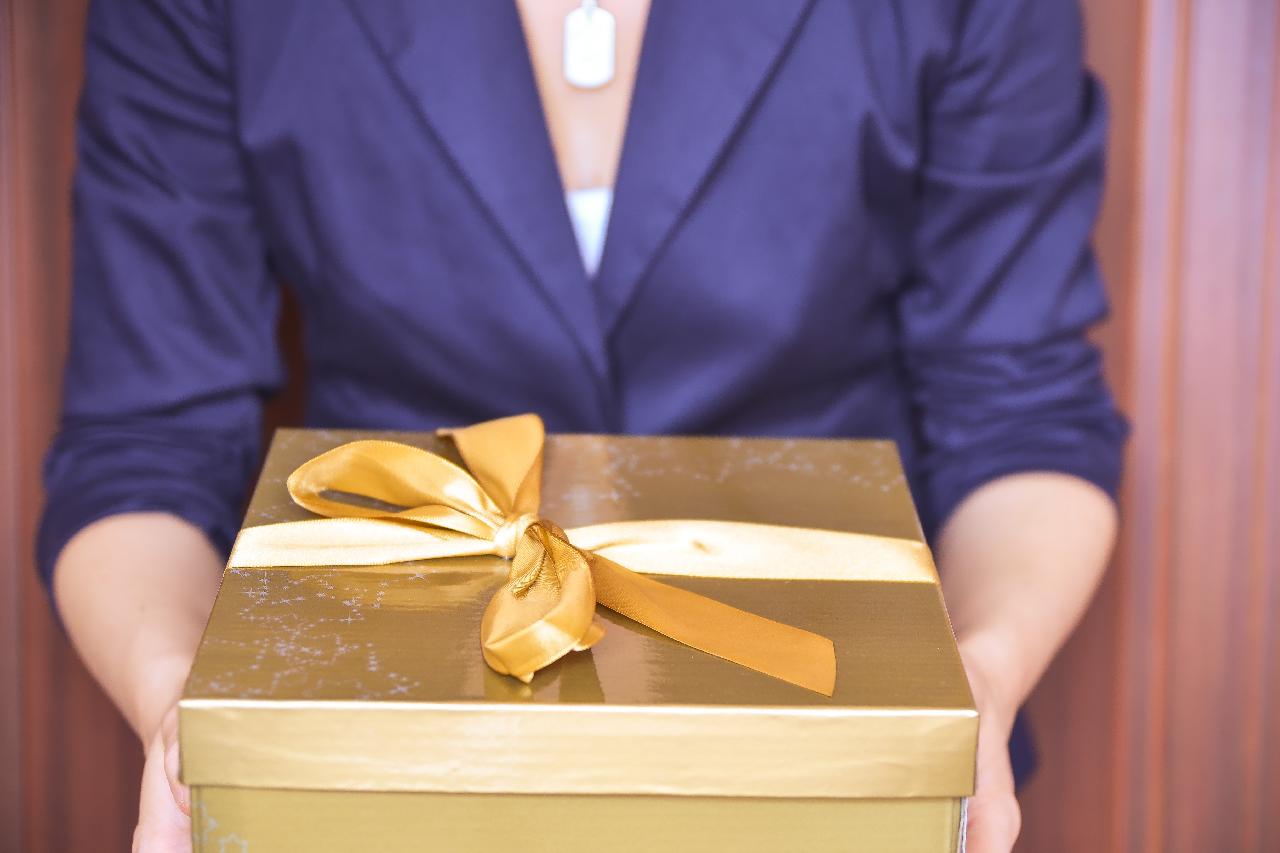 woman bearing a wrapped gift